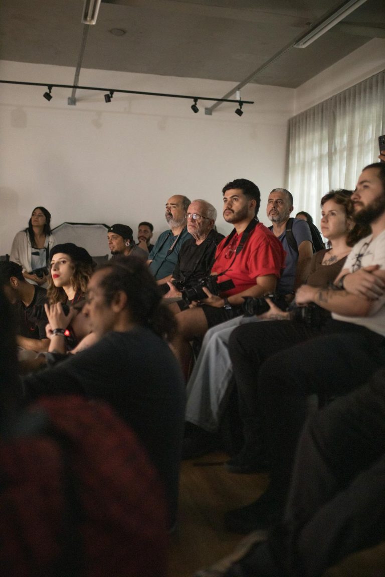 A diverse group of adults attentively participating in an indoor seminar setting.